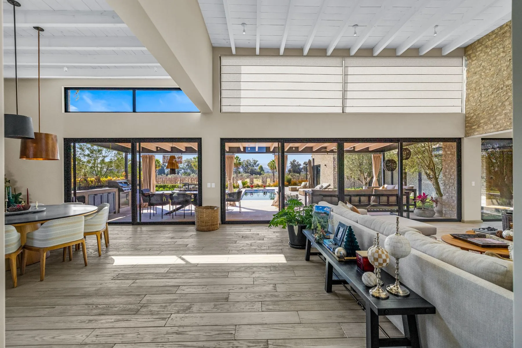 Open-plan great room with folding glass walls onto a pool terrace