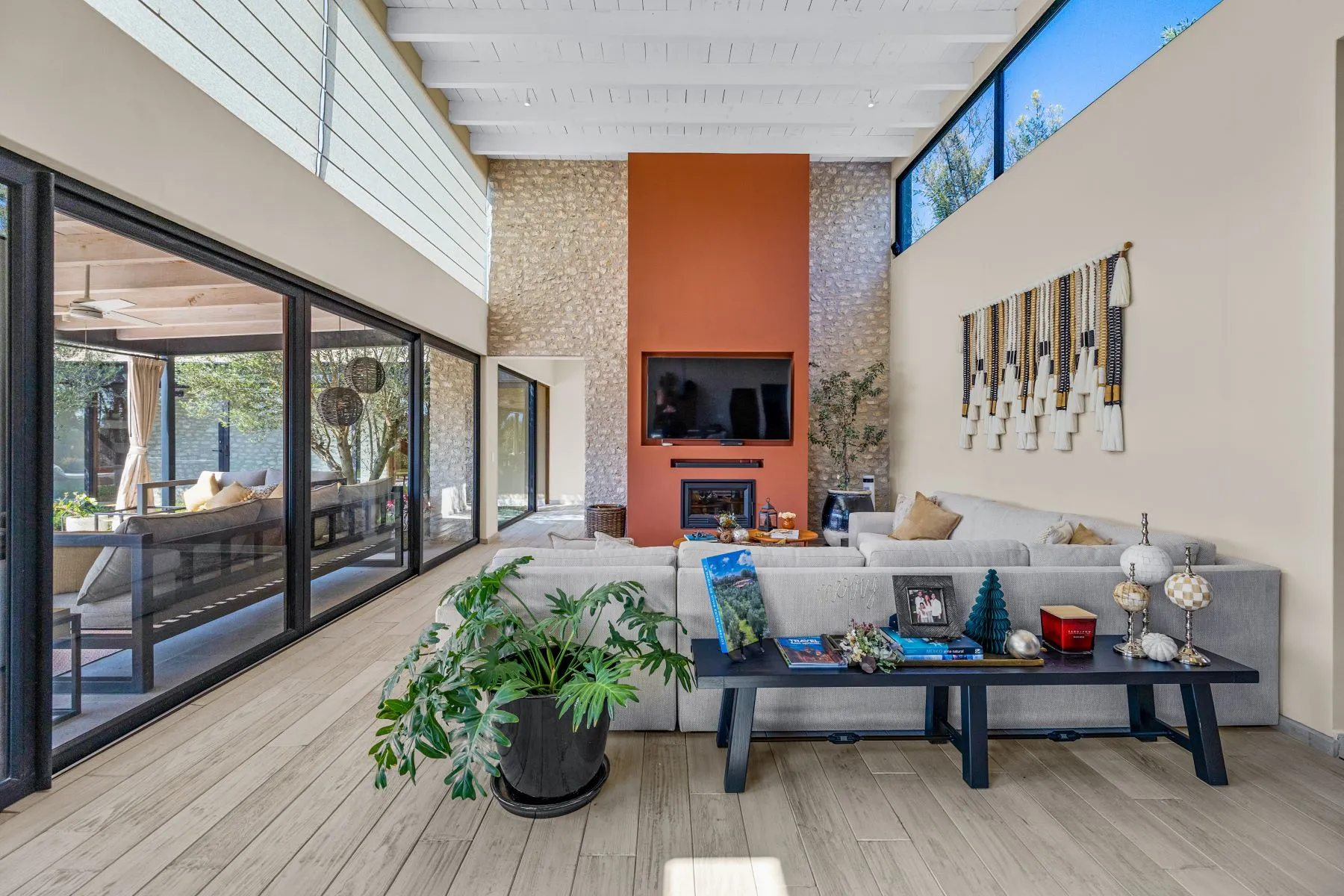 Living room with a terracotta fireplace wall, stone masonry and a pale sectional sofa